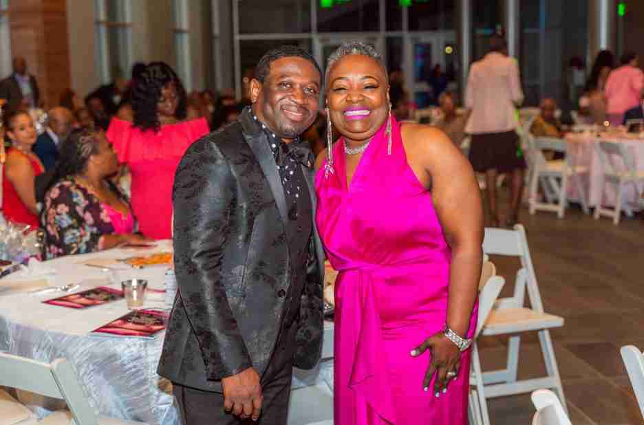 A smiling couple dressed elegantly at a formal event.