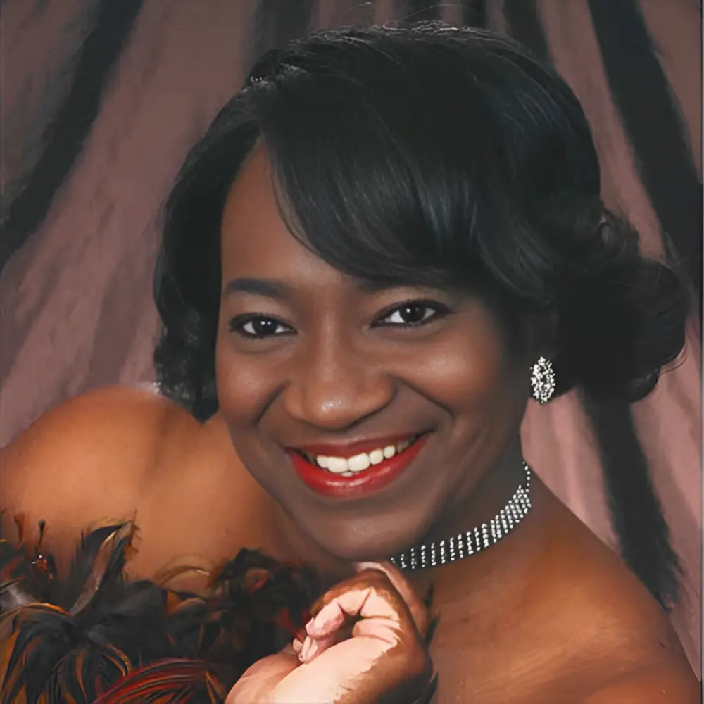 Smiling woman with elegant jewelry and feathers.