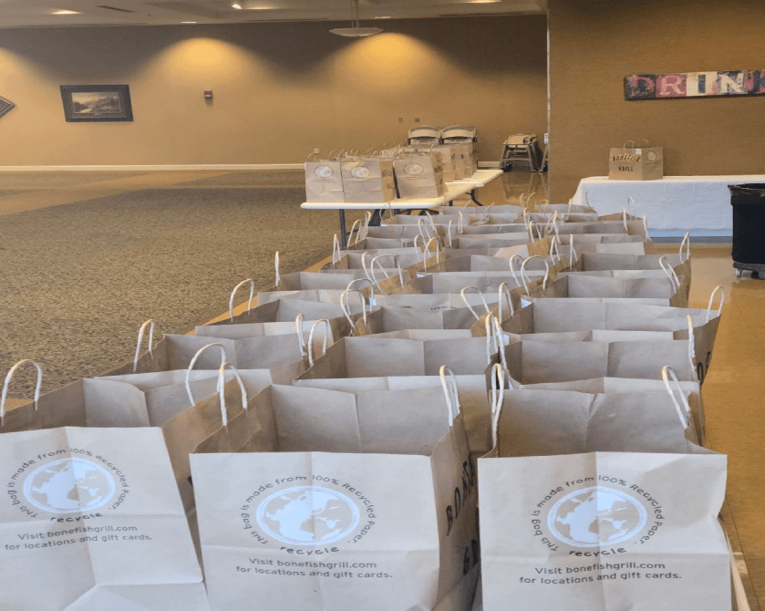 Rows of paper bags on tables in room.
